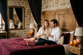 Couple romantique dans une love room avec pétales de roses et bougies dans un hôtel boutique