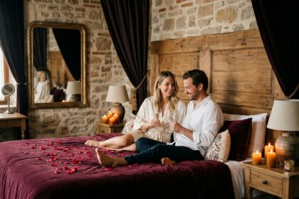 Couple romantique dans une love room avec pétales de roses et bougies dans un hôtel boutique