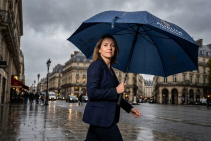 Femme professionnelle tenant un parapluie personnalisé avec logo d'entreprise sous la pluie à Paris
