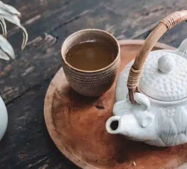 white and brown ceramic teapot on wooden tray