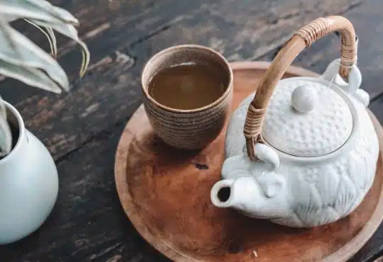white and brown ceramic teapot on wooden tray